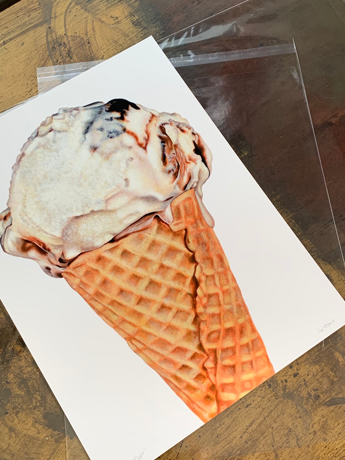 Fudge Ripple ice cream cone art print by Kim Testone, featuring a single scoop of fudge ripple ice cream, slightly  melting, in a cone, set against a white background.